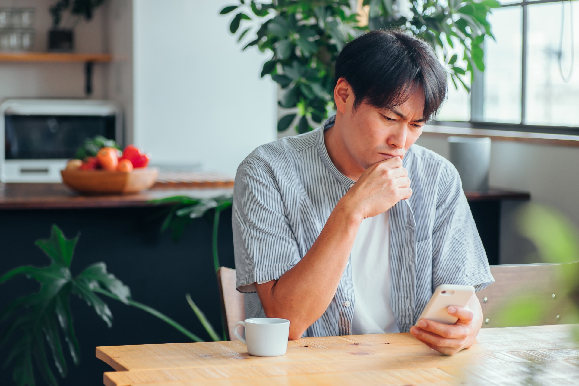 スマホを見て落ち込む男性